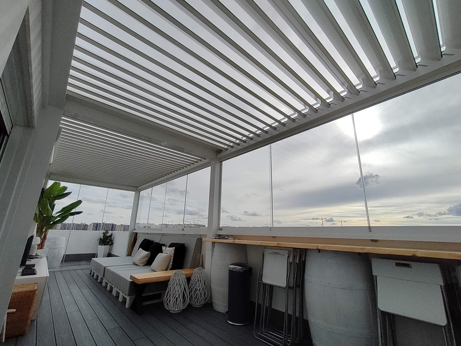 Pérgola bioclimática con cerramiento de cristal en una terraza