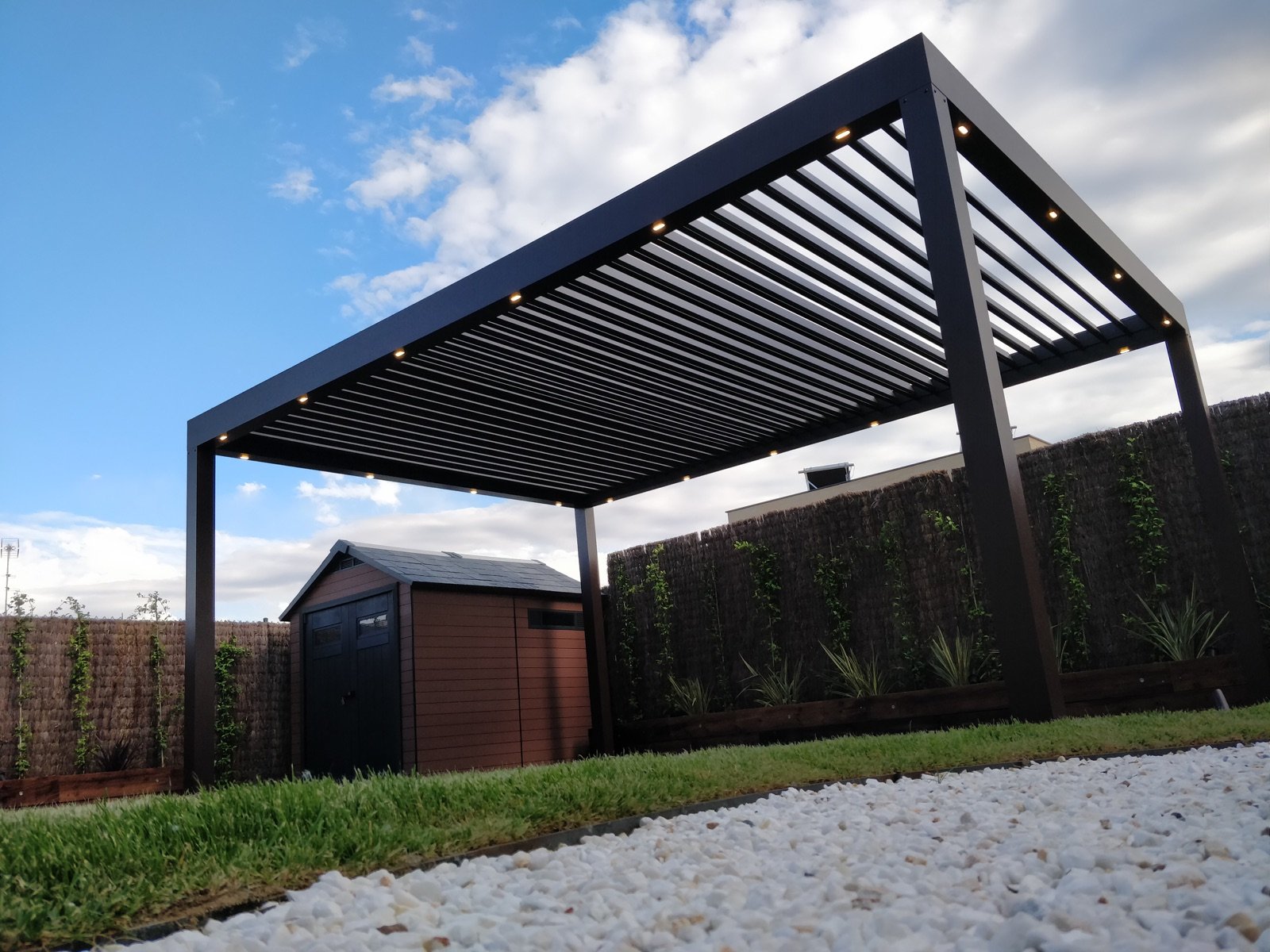 Pérgola bioclimática instalada en un jardín